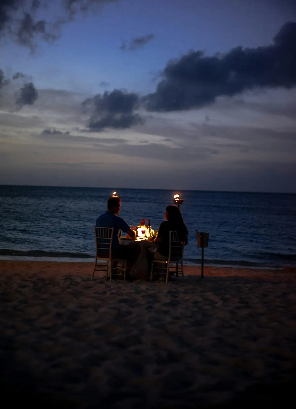 Candlelit dinner for two on a Bali beach at dusk